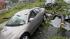 Cars are damaged and debris lies on the street...