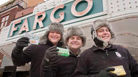 Employees of the Just Born candy company -- which makes Peeps, Mike and Ikes and other popular candies -- are enjoying chilly Fargo, N.D., instead of balmy Hawaii after corporate sales goals werent met. Two dozen workers, who are in town for meetings, received fleece jackets and bomber hats. Pictured (from left) in front of the Fargo Theatre on Tuesday, Dec. 14, 2010, are: Dave Bayha, channel team manager, Josh Halpern, director of U.S. sales, and Jim Costas, channel team manager. (AP Photo/Ann Arbor Miller)