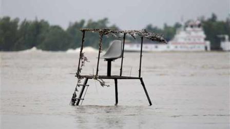A deer blind sits mostly submerged in floodwaters as a tugboat pushes barges along the Mississippi River in the background in St. Francisville, La., Friday, May 20, 2011. Residents were leaving in the face of a mandatory evacuation order set to kick in on Saturday as Mississippi River water flowing through the Morganza spillway is expected to reach communities in the Atchafalaya Basin. (AP Photo/Gerald Herbert)