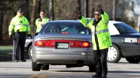 Police direct traffic at a roadblock, Friday, April 13, 2012 in Greenland, N.H. as they continue to investigate a shooting where five police officers were shot Thursday evening. Officials said Greenfield Police Chief Michael Maloney was killed, and four detectives from other departments were injured. Two remained in intensive care Friday; the other two were treated and released. The man suspected of killing Maloney and wounding four other officers was found dead along with a female acquaintance early Friday, ending an overnight standoff. (AP Photo/Jim Cole)