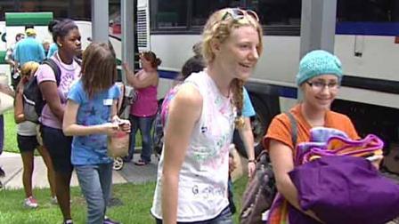 Children line up and load buses bound for Camp Periwinkle
