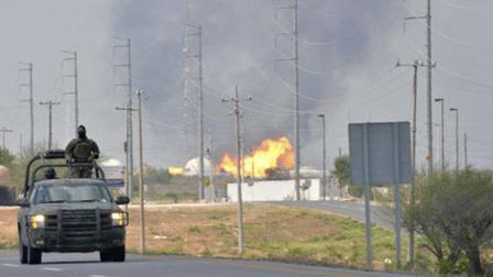 A Mexican army vehicle patrols on a road as fire and smoke rise from a gas pipeline distribution center in Reynosa, Mexico near Mexicos border with the United States, Tuesday Sept. 18, 2012. Mexicos state-owned oil company, Petroleos Mexicanos, also known as Pemex said the fire had been extinguished and the pipeline had been shut off but ten people were killed during the incident. (AP Photo/El Manana de Reynosa)