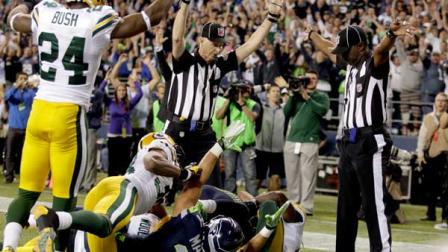 Officials signal a touchdown by Seattle Seahawks wide receiver Golden Tate, obscured, on the last play of an NFL football game against the Green Bay Packers, Monday, Sept. 24, 2012, in Seattle. The Seahawks won 14-12. (AP Photo/Stephen Brashear)