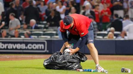 An Atlanta Braves official picks up trash on the field during the eighth inning of the National League wild card playoff baseball game against the St. Louis Cardinals, Friday, Oct. 5, 2012, in Atlanta. The Cardinals won baseballs first wild-card playoff, taking advantage of a disputed infield fly call that led to a protest and fans littering the field with debris to defeat the Braves 6-3. (AP Photo/Todd Kirkland)