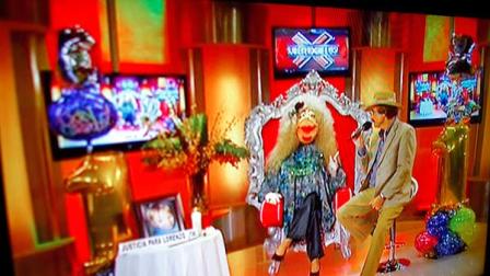 In this Oct. 17, 2012, a TV show called La Comay (roughly translated to The Godmother), is seen on a TV set in San Juan, Puerto Rico. This five-foot tall puppet with outlandish red lips, a shrill voice and a penchant for salacious details rules Puerto Ricos gossip circuit, with legions tuning into her show every afternoon ready for the latest bombshell. And La Comay dishes it out with ominous music playing in the background, talking about everyone from Mexican crooner Luis Miguel to Puerto Ricos own Miss Universe beauty queen Zuleyka Rivera. (AP Photo/Ricardo Arduengo)