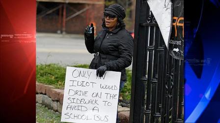 Shena Hardin holds up a sign to serve a highly public sentence Tuesday, Nov. 13, 2012, in Cleveland, for driving on a sidewalk to avoid a Cleveland school bus that was unloading children. A Cleveland Municipal Court judge ordered 32-year-old Hardin to serve the highly public sentence for one hour Tuesday and Wednesday. (AP Photo/Tony Dejak)