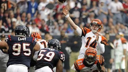 Cincinnati Bengals quarterback Andy Dalton (14) throws a pass over Cedric Benson (32) against the Houston Texans during the first quarter of an NFL wild card playoff football game Saturday, Jan. 7, 2012, in Houston. (AP Photo/Dave Einsel)
