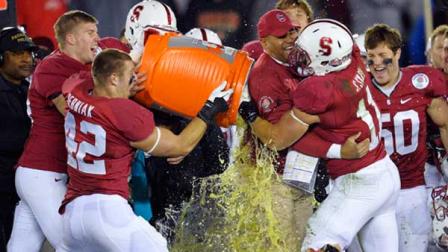 Stanford head coach David Shaw is doused by outside linebacker Alex Debniak (42) and hugged by inside linebacker Shayne Skov (11) as they celebrate their 20-14 win over Wisconsin in the Rose Bowl NCAA college football game, Tuesday, Jan. 1, 2013, in Pasadena, Calif. (AP Photo/Mark J. Terrill)