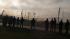 Residents watch as smoke rises from the Air...
