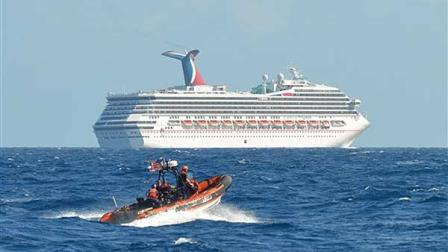 In this image released by the U.S. Coast Guard on Feb. 11, 2013, a small boat belonging to the Coast Guard Cutter Vigorous patrols near the cruise ship Carnival Triumph in the Gulf of Mexico, Feb. 11, 2013. The Carnival Triumph has been floating aimlessly about 150 miles off the Yucatan Peninsula since a fire erupted in the aft engine room early Sunday, knocking out the ships propulsion system. No one was injured and the fire was extinguished. (AP Photo/U.S. Coast Guard- Lt. Cmdr. Paul McConnell)
