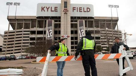 Texas A&M security personnel who wished not to be identified barricade the entrance to KyleField after a bomb threat Wednesday Feb. 20, 2013 in College Station, Texas. Texas A&M University is investigating a bomb threat at KyleField that prompted the school to issue a code maroon safety advisory and close the stadium and nearby buildings. (AP Photo/ Patric Schneider)