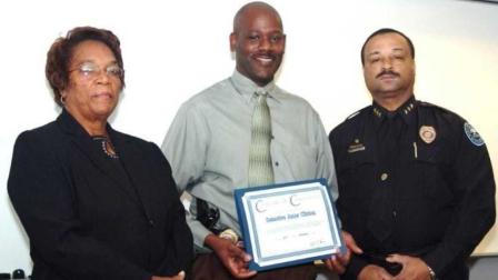 In this 2008 image provided by the Jackson, Miss. Police, Detective Eric Smith, center, flanked by Chief Rebecca Coleman, left, and Assistant Chief Lee Vance accepts the Certificate of Commendation on behalf of Detective Amos Clinton in Jackson, Miss. Authorities say a murder suspect shot Smith inside the Jackson police headquarters and that both the suspect and detective are dead. (AP Photo/Jackson Police)