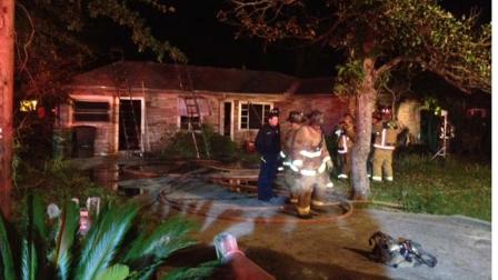 Officials say a Houston firefighter was injured after falling through the roof of this home