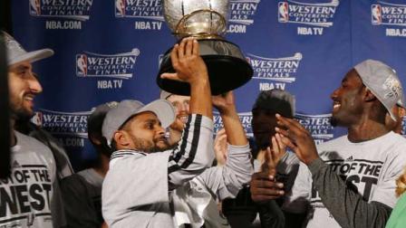 San Antonio players Manu Ginobili, left, and DeJuan Blair, right, watch as Patty Mills raises the Western Conference trophy after the Spurs defeated the Memphis Grizzlies 93-86 in game 4 of the NBA basketball playoff series, Monday, May 27, 2013, in Memphis, Tenn. The Spurs advance to the NBA finals. (AP Photo/Pool-Rogelio V. Solis)