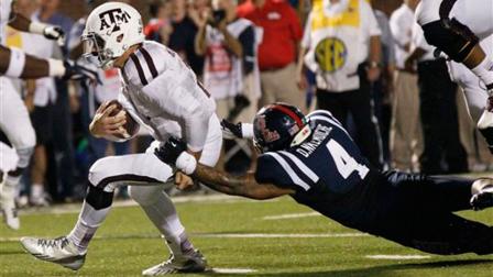 Texas A&M quarterback Johnny Manziel (2) drags Mississippi linebacker Denzel Nkemdiche (4) as he breaks free for a five-yard touchdown run in the second half of their NCAA college football game on Oct. 12, 2013