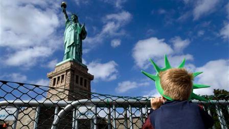 Jackson Blendowski, 6, of New Hampshire, peers up at the Statue of Liberty in New York Harbor, Sunday, Oct. 13, 2013, in New York