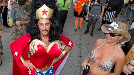 In this Friday, Oct. 25, 2013, Sam Trophia, left, poses in his Wonder Woman costume during the Fantasy Fest Masquerade March in Key West