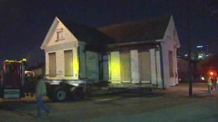 One of six houses is moved about half a mile to its new home where it will be restored
