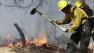 An AmeriCorps volunteer firefighter assigned to the El Paso County Sheriffs Office, Woodland Fire Crew, helps contain a spot fire in an evacuated area of forest, ranches and residences, in the Black Forest wildfire area, north of Colorado Springs, Colo.
