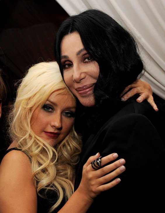Cher and Christina Aguilera pose together while...