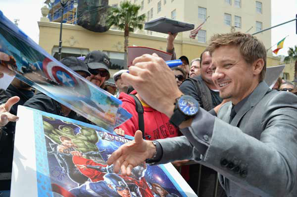 Actor Jeremy Rennersigns autographs while...
