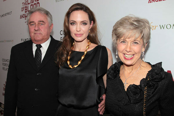 In this Dec. 5, 2011 photo, from left, Bill Pitt, father of actor Brad Pitt, actress Angelina Jolie and Jane Pitt, mother of Brad Pitt, pose at the New York Premiere of  'In The Land Of Blood and Honey,' a film written and directed by Angelina Jolie.