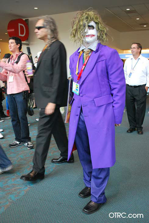 A fan dressed in costume as the Joker appears in...