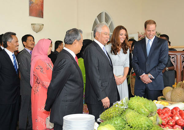 In this photo released by Malaysia's Information Department, Malaysian Prime Minister Najib Razak, third from right, introduces local fruits to Britain's Prince William, right, and his wife Kate, second from right, the Duke and Duchess of Cambridge.