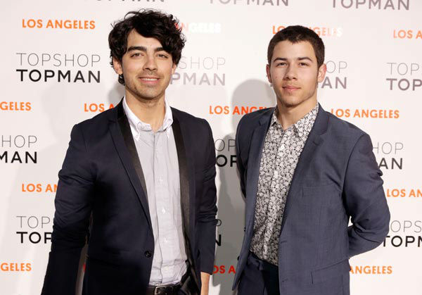 Singers Joe Jonas (L) and Nick Jonas wearing...