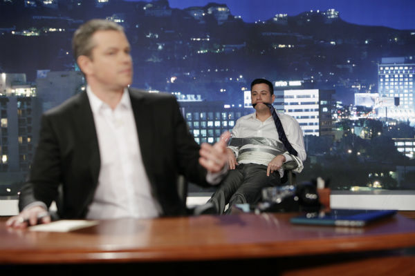 Damon sits in Jimmy Kimmel's desk chair as the...
