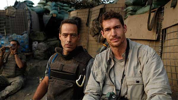 In this 2007 publicity image released by Outpost Films, directors Sebastian Junger, left, and Tim Hetherington are shown at the Restrepo outpost in the Korengal Valley, Afghanistan, during the filming of their documentary 'Restrepo.'