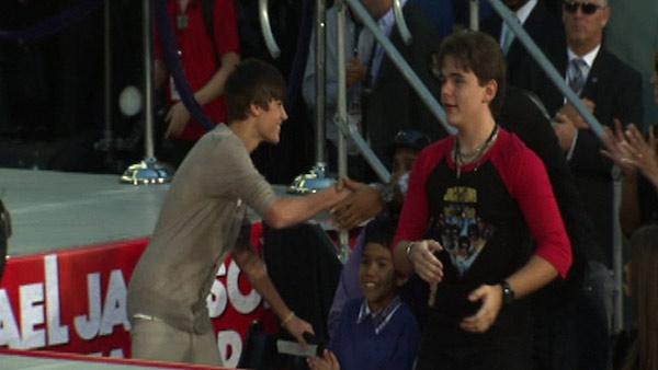 Justin Bieber (left) shakes the hand of an unidentified audience member as Blanket and Prince Jackson (right) look on at Michael Jackson's hand and footprint ceremony at the Grauman's Chinese Theatre on Jan. 26, 2012.