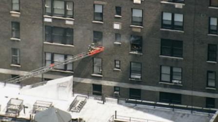 A firefighter climbs onto a ladder placed outside a New York apartment building where Robert De Niro lives, on June 8, 2012.