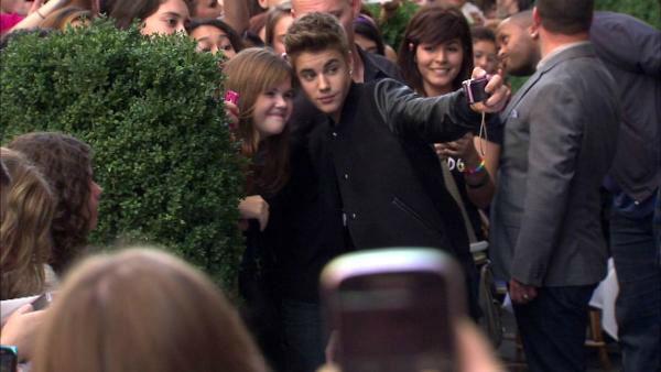 Justin Bieber poses with fans following a sidewalk performance for 'Oprah's Next Chapter' outside RL Restaurant in Chicago, Illinois on Wednesday, Oct. 24, 2012.