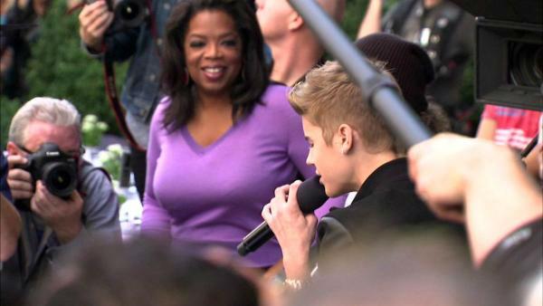 Oprah Winfrey watches on while Justin Bieber delivers a sidewalk performance for 'Oprah's Next Chapter' outside RL Restaurant in Chicago, Illinois on Wednesday, Oct. 24, 2012.