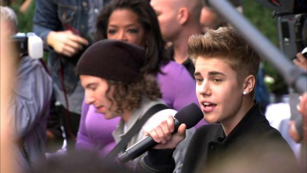 Oprah Winfrey watches on while Justin Bieber delivers a sidewalk performance for 'Oprah's Next Chapter' outside RL Restaurant in Chicago, Illinois on Wednesday, Oct. 24, 2012.