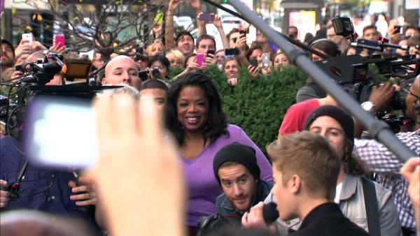 Oprah Winfrey watches on while Justin Bieber delivers a sidewalk performance for 'Oprah's Next Chapter' outside RL Restaurant in Chicago, Illinois on Wednesday, Oct. 24, 2012.