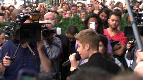 Oprah Winfrey watches on while Justin Bieber delivers a sidewalk performance for 'Oprah's Next Chapter' outside RL Restaurant in Chicago, Illinois on Wednesday, Oct. 24, 2012.