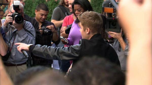 Oprah Winfrey watches on while Justin Bieber delivers a sidewalk performance for 'Oprah's Next Chapter' outside RL Restaurant in Chicago, Illinois on Wednesday, Oct. 24, 2012.