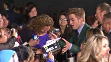 Robert Pattinson signs fans memorabilia at the premiere of Twilight: Breaking Dawn - Part 2 at the Nokia Theatre L.A. Live in Los Angeles on Nov. 12, 2012. - Provided courtesy of OTRC