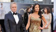 Catherine Zeta-Jones and Michael Douglas walk the red carpet at the 2013 Oscars on Sunday, February 24.