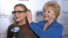 Carrie Fisher and her mother, actress Debbie Reynolds, talk to OTRC.com at the elder stars movie memorabilia auction event near Los Angeles on May 14, 2014. - Provided courtesy of OTRC