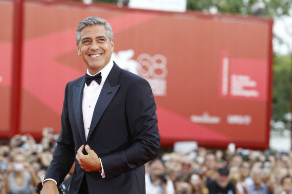 George Clooney poses on the red carpet for the...