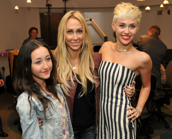 Miley Cyrus, right, poses with her mother...