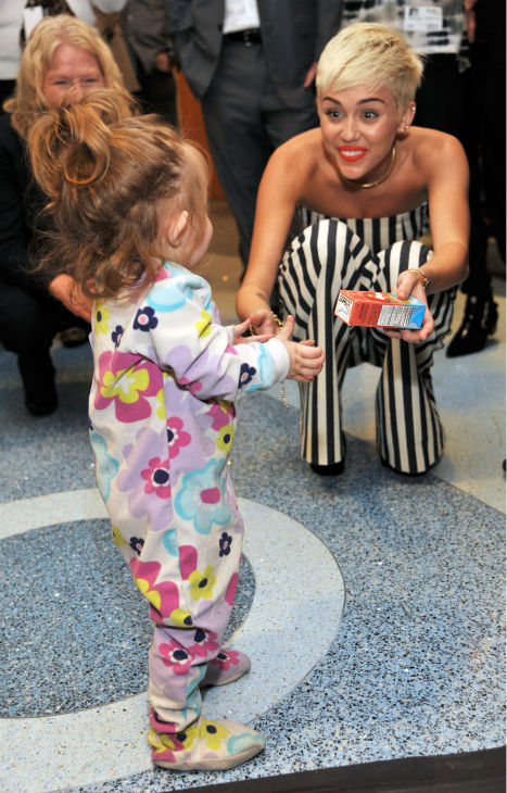 Miley Cyrus plays with patient Janessa Martinez,...