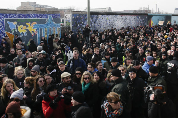 Thousands of protesters follow a truck with...