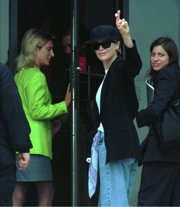 Kim Basinger, center, raises crossed fingers as...