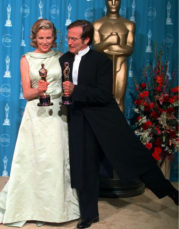 Kim Basinger and Robin Williams hold their...
