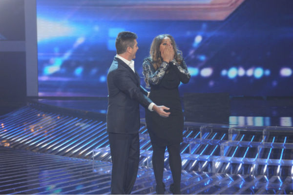 Co-judge Simon Cowell (L) reacts as Melanie Amaro (R), the contestant he mentored, is announed the winner of season 1 of the FOX show 'The X Factor' on Dec. 22, 2011.