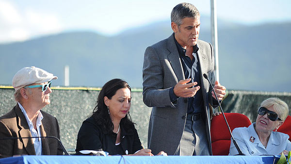 Clooney appears in a photo speaking to residents...